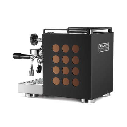 <img src="appartamento_black_copper_back.jpg" alt="黑金版 Rocket Espresso Appartamento 咖啡機的背面，清楚展示了背板上的金屬品牌吊牌，凸起字體寫著 'Rocket Espresso Milan'，具有立體感。">